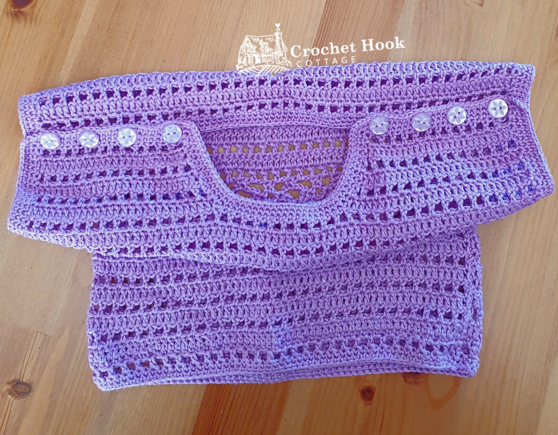 Purple Cuddles Baby Shirt, fits 6 to 12 months old, positioned to show the buttons on the shoulders and the neckline - www.crochethookcottage.com