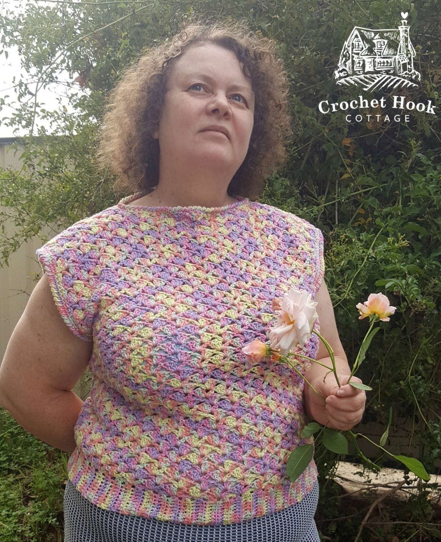 person wearing the Camilla color Shell-patterned Sleeveless Ladies Top, size ladies medium, holding a bunch of apricot roses, looking up at the sky - www.crochethookcottage.com