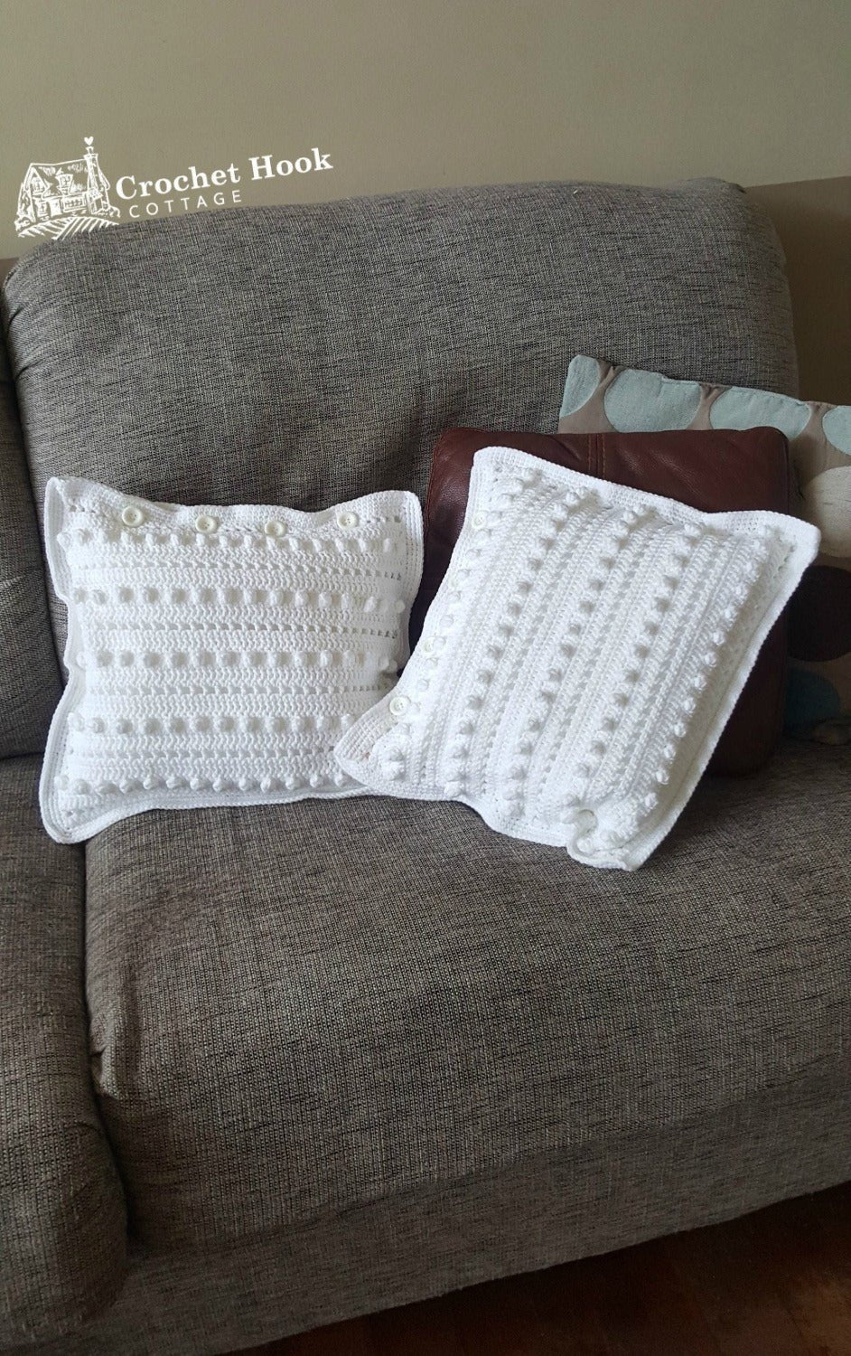 two white string of pearls cushion covers with cushions inserted on a sofa - www.crochethookcottage.com