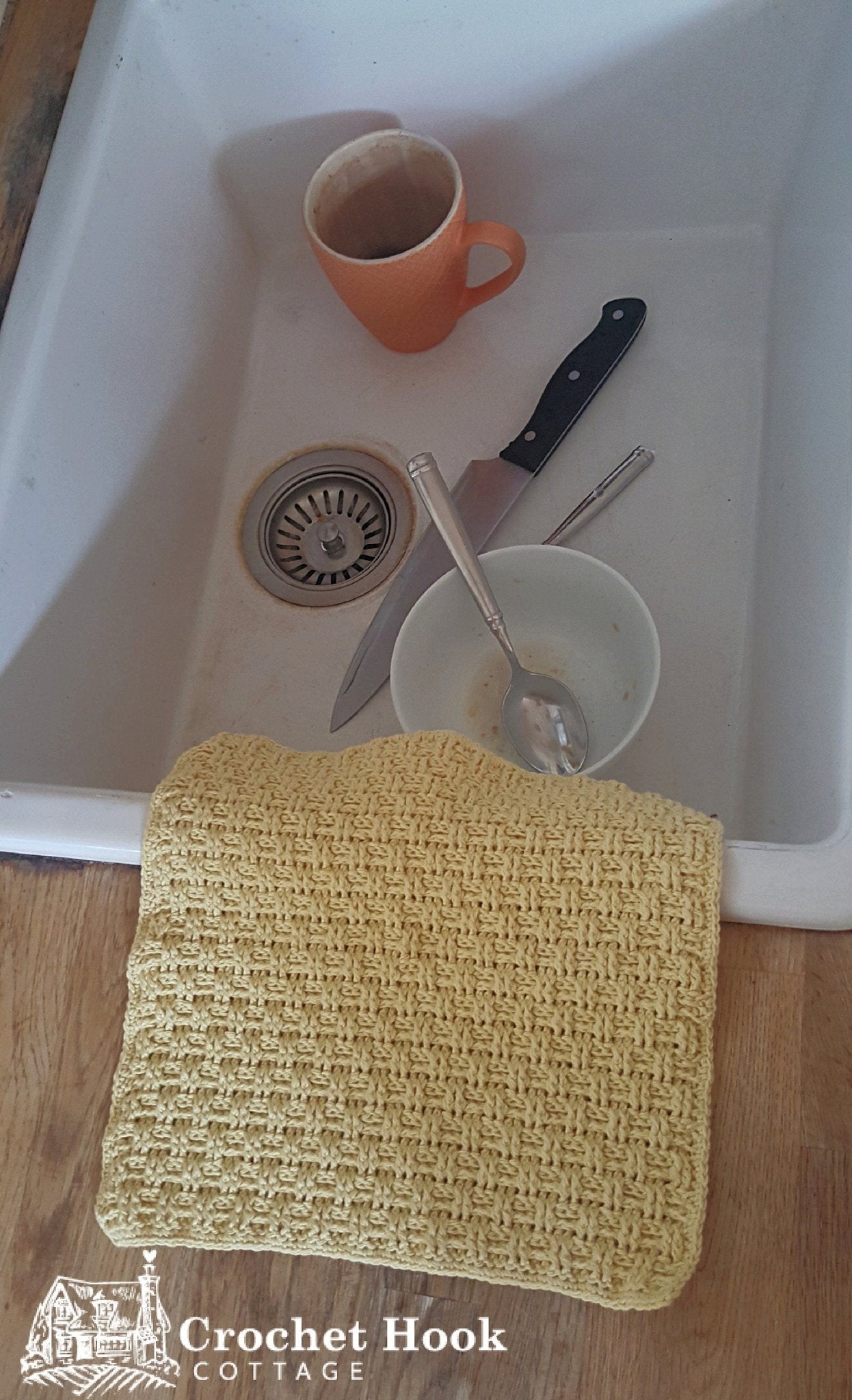 Yellow cotton crocheted Basketweave pattern Cleaning Cloth, placed next to a sink filled with used dishes - www.crochethookcottage.com