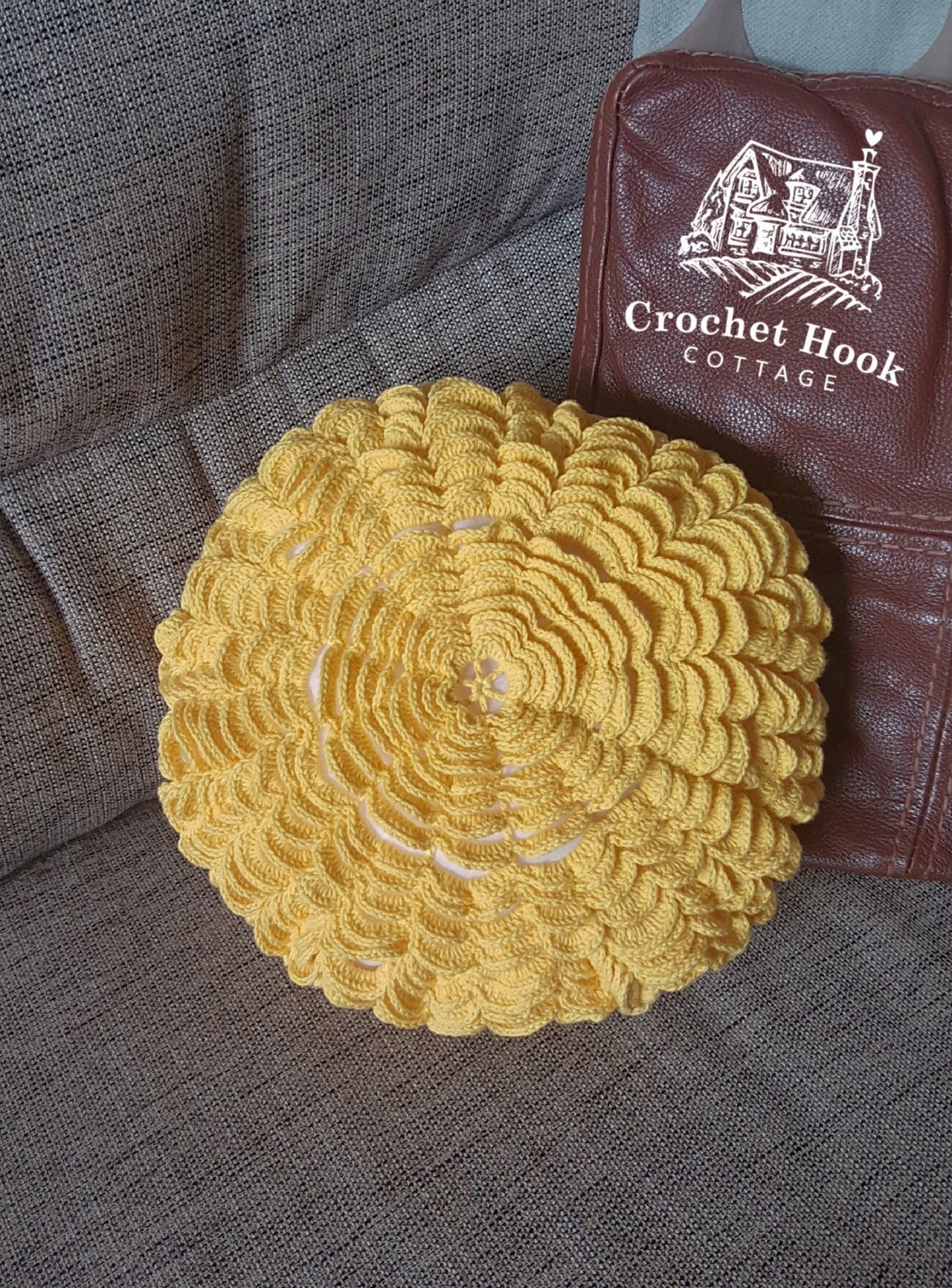 Front view of the Yellow Round Petal Cushion Cover showing the crocheted petals, with cushion inserted, propped on a sofa - www.crochethookcottage.com